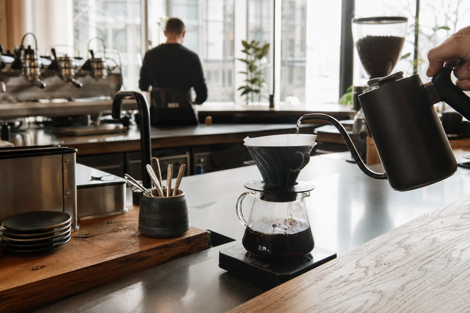 KaffeBaren Vejles varme interiør med højloftet rum og kunstnerplakater