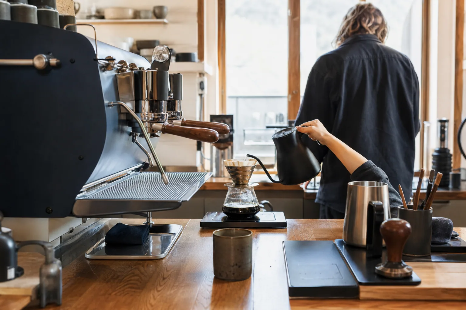 Barista ved espressomaskine i travlt skift